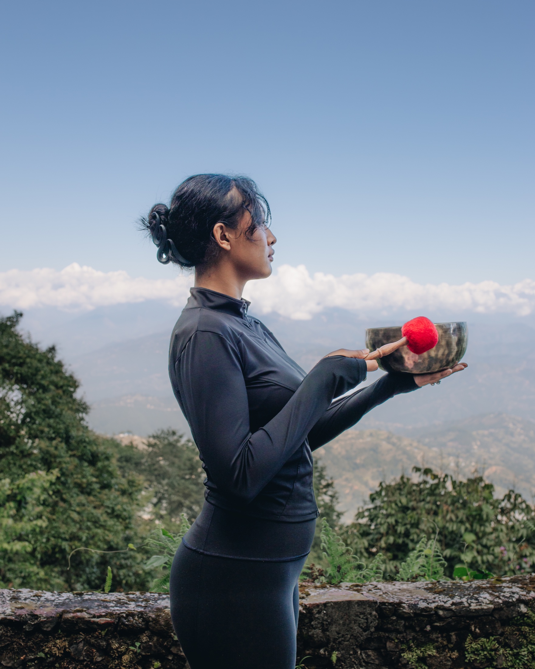 山々を背景にYECHANシンギングボウルを手にする女性